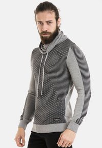 Grauer Hoodie mit strukturierten Strickmustern, einem Schalkragen und einer Mischung aus gestreiften und einfarbigen Bereichen. Enthält Kordeln und gerippte Bündchen.