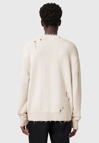 Beige Übergröße Pullover mit distressed Details, gerippten Bündchen und Saum, in lockerem Schnitt und weichem Material.