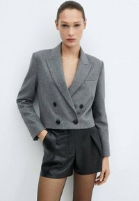 Grijze dubbelgeknoopte cropped blazer in een gestructureerde stof met zwarte knopen, notch-ook en een slanke, aansluitende pasvorm; gecombineerd met zwarte leren short.