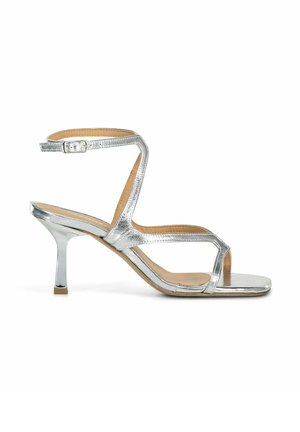 Sandal in metallo argentato con tacco alto, caratterizzato da cinturini incrociati, fibbia alla caviglia, design open toe e tacco a blocco sottile. Texture liscia.