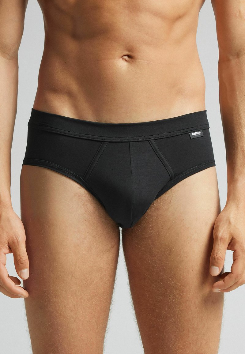 Svarta bomullsshorts med kort benlängd, slät yta, elastiskt midjeband och sömnadsdetaljer. Inga synliga mönster eller accenter.