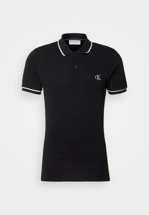 Black polo shirt made of cotton, featuring a slight stretch, with a white collar and sleeve trim, and a small logo on the chest.