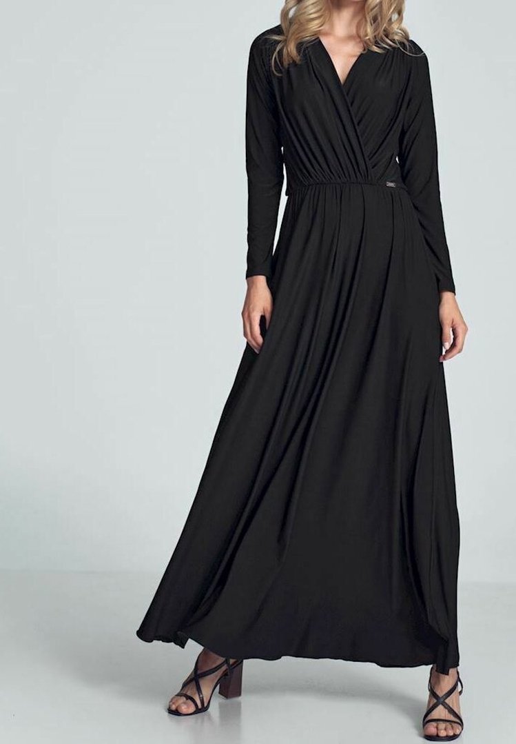 Svart maxiklänning med långa ärmar, crossover V-ringning, samlad midja, flödande kjol och mjuk textur. Kombinerad med sandaler med klack och remmar.