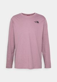 Triko s dlouhým rukávem vyrobené z měkké, lehké látky ve světle levandulové barvě s černým logem na levé hrudi a klasickým kulatým výstřihem.