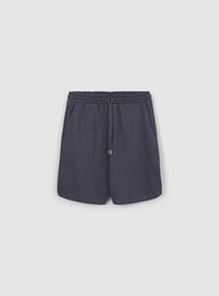 Shorts gris foncé en tissu doux. Ils comportent une ceinture élastique avec cordon de serrage, des poches latérales et une coupe décontractée.