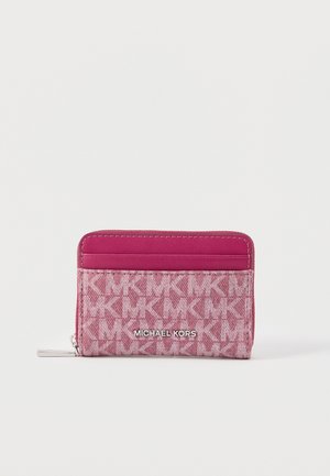Porte-cartes Michael Kors rose avec un motif répété du logo MK et une fermeture éclair argentée, doté d'une poche frontale et d'une plaque avec logo.