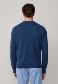 Modrá pletená mikina s okrúhlym výstrihom a rebrovaným zakončením. Má hladkú štruktúru a priliehavý strih. Žiadne viditeľné vzory ani akcenty.