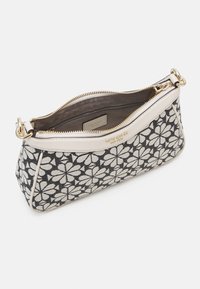 Sac à main noir et blanc à motifs floraux avec fermeture éclair, accents crème et quincaillerie dorée. Extérieur en tissu texturé.