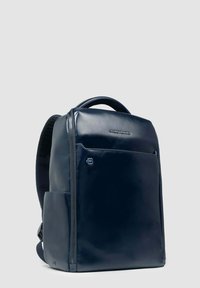 Mochila de color azul marino, brillante, con un diseño aerodinámico, bolsillo frontal con cremallera, respaldo acolchado y correas para los hombros ajustables. Textura suave.