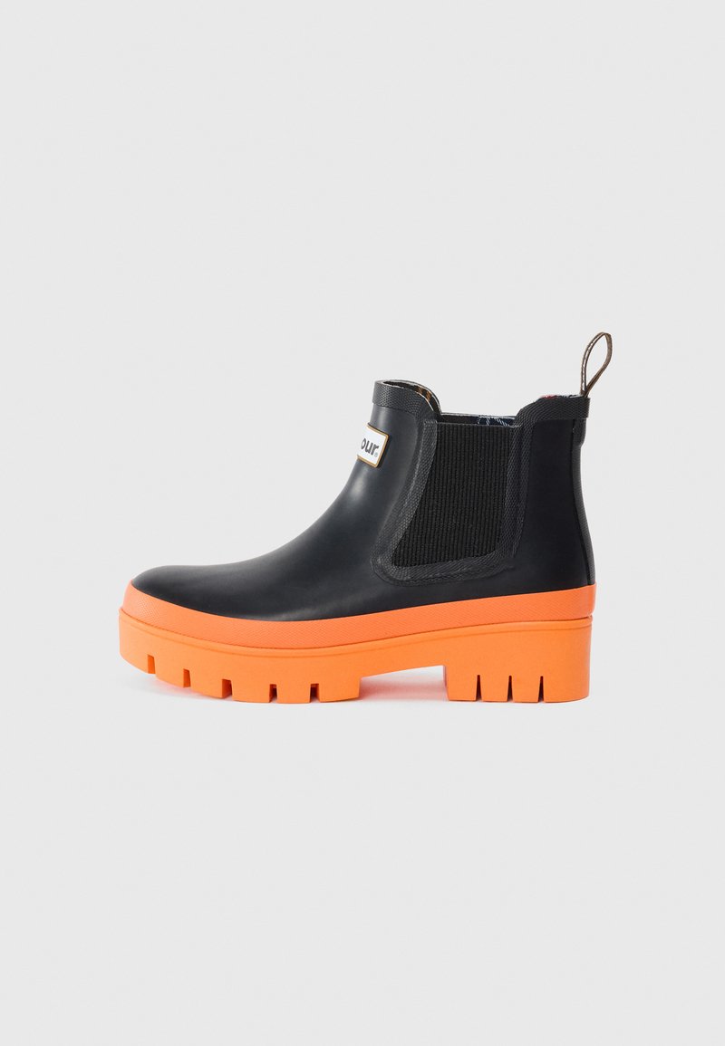 Bottes en caoutchouc noires jusqu'à la cheville avec une semelle orange épaisse, des panneaux latéraux élastiques et une languette pour un enfilage facile. Semelle plate pour une bonne traction.
