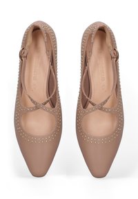 Beige Lederstiefel mit spitzen Zehen, ausgeschnittenen Designs und goldenen Nietenakzenten, mit Kreuzriemen und einem kleinen Schnallenverschluss.