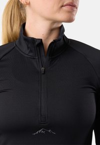 Top sportivo nero con collare alto e chiusura con zip. Presenta un tessuto testurizzato e una sottile grafica di montagne vicino all'orlo.