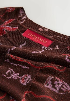 Brauner Strickpullover mit roten und weißen Weihnachtsmustern und einem roten Etikett mit der Aufschrift "Christmas at Next" im Kragen.