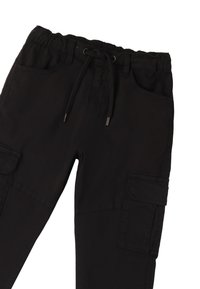 Pantalones cargo negros con cinturilla elástica y cordón. Sus características incluyen múltiples bolsillos y una textura de tejido suave y duradera.