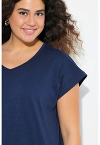 Marinblå V-ringad t-shirt med korta, rullade ärmar, tillverkad av mjukt, lätt material; slät textur med en avslappnad passform.