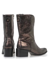 Bruna cowboystövlar med en sprucken yta, rund tå och låg klack; har en dragkedjestängning och ett gyllene accent på sidan.