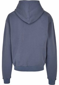 Halli särgil helesinine puuvill, millel on lõdva lõikega, soonikkoes alläär ja varrukad, sile ja harjatud tekstuur ning nähtavat logo pole.