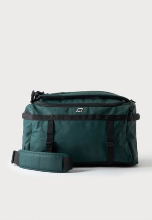 Bolsa deportiva rectangular de color verde oscuro con correas negras, una correa de hombro acolchada, cierre con cremallera en la parte superior y un pequeño logo blanco en el centro frontal.
