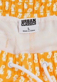 Narancssárga fürdőnadrág tengeri ló mintával, fehér hálós béléssel, rugalmas derékpánttal, húzózsinórral és "Urban Classics" címkével. L-es méret.