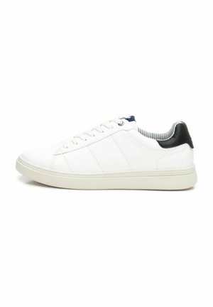 Zapatilla blanca con cordones, con una parte superior de cuero suave, tres rayas cosidas, cuello acolchado y una tapa de talón negra en contraste.