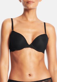 Svart vadderad behå med justerbara axelband, spetsdetaljer längs bandet och en slät tygfinish. Underwire stöd förstärker formen.