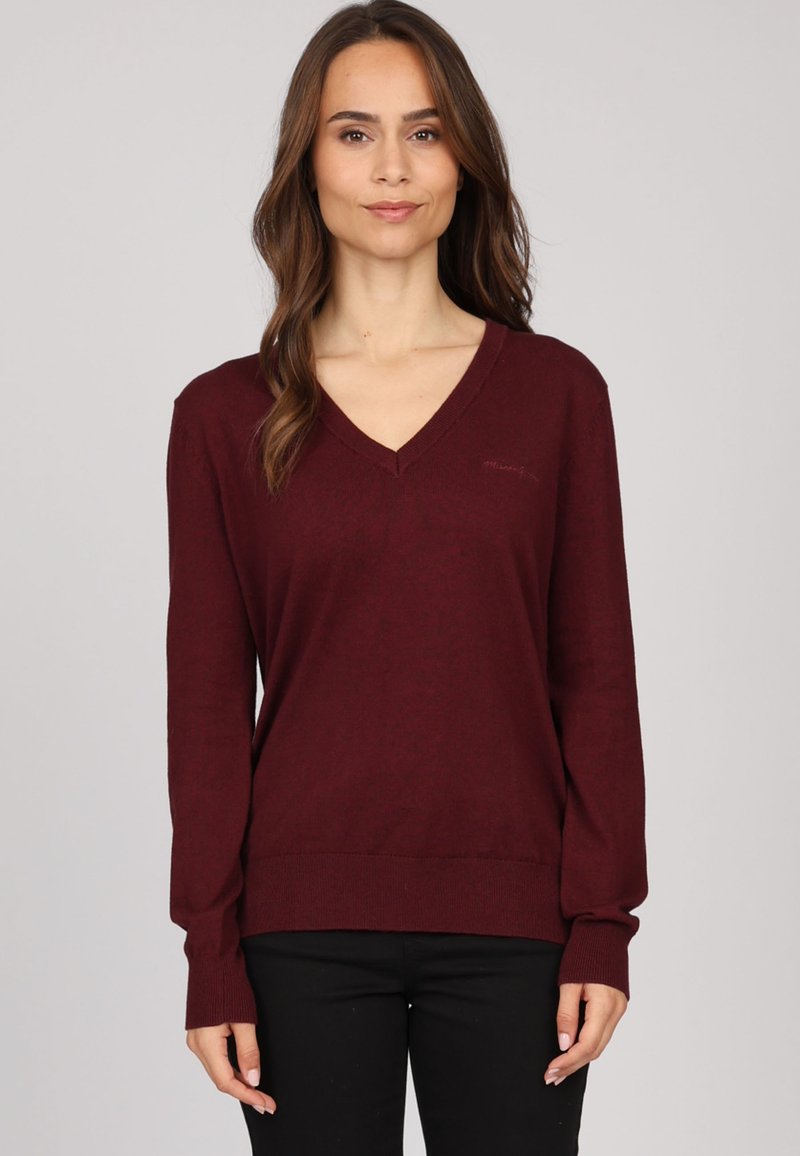 Pull V en bourgogne en tissu tricoté doux, à manches longues, avec des poignets et un ourlet côtelés, présentant un discret détail de logo sur la poitrine.