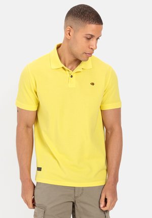 Gelbes Polo-Shirt mit Kragen und zwei Knöpfen, mit einem kleinen Logo auf der Brust und kurzen Ärmeln. Texturiertes Material, lässige Passform.