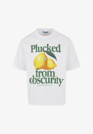 T-shirt bianca in cotone a maniche corte con una grafica che raffigura due limoni gialli e testo in verde e nero che recita "Colti dall'oscurità."