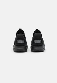 Scarpe sportive nere con una tomaia in mesh testurizzato, collo imbottito e suola in gomma. Presentano un logo "PUMA" argento ben visibile sul tallone.