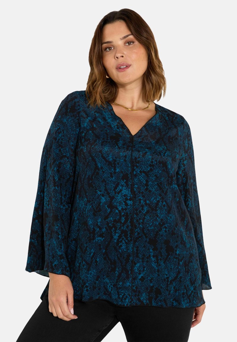 Halenka s dlouhým rukávem v modré a černé barvě s hadím vzorem, V-výstřihem, volnými rukávy a hladkou texturou. Má mírný drapérie.