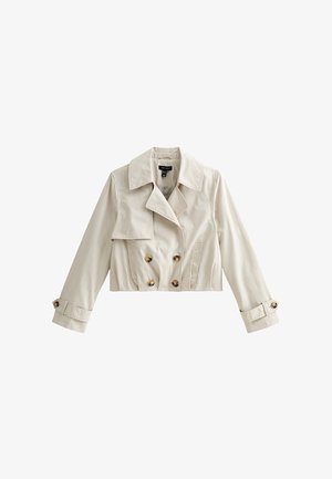 Trench coat corto color crema con bottoni doppiopetto, colletto ampio, patta frontale, tasche laterali e cinturini con bottoni sulle maniche.