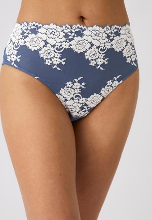 Ropa interior azul de tiro alto con patrones de encaje floral blanco, usada por una persona que muestra el torso inferior y la parte superior de los muslos.
