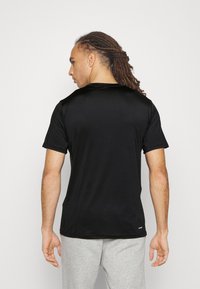 T-shirt sportivo nero a maniche corte realizzato in tessuto traspirante, caratterizzato da una texture liscia e un colletto tondo, con una schiena semplice.