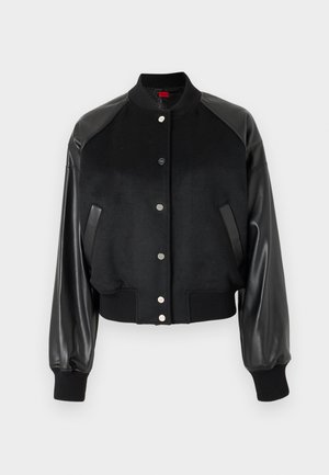 Black bomber jacket featuring a wool body and leather sleeves. Ribbed cuffs and hem. Snap-button closure. Two side pockets for utility.