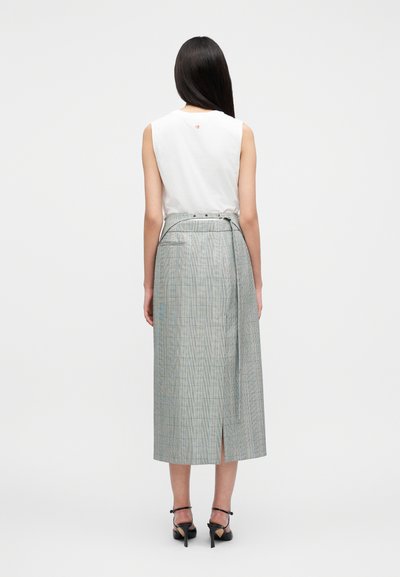 Λευκό αμάνικο τοπ συνδυασμένο με μακριά καρό φούστα που διαθέτει πλαϊνή σκίσιμο και αποσπώμενη ζώνη. Η φούστα έχει σχέδιο σε ανοιχτό μπλε, γκρι και πορτοκαλί χρώμα.