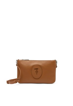 Brun læderhåndledstaske med en tynd rem og et ovalt præget logo i midten, sikret med en øverste lynlås.