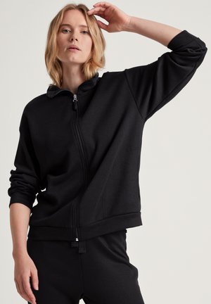 Felpa nera con zip, maniche lunghe, polsini a costine e una texture morbida. Presenta un colletto alto e un design con vestibilità comoda.