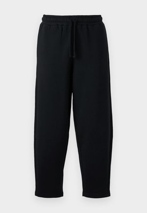 Sorte sweatpants med elastisk talje og snøre. Lavet af blødt stof, med en afslappet pasform og tapered ben-design.