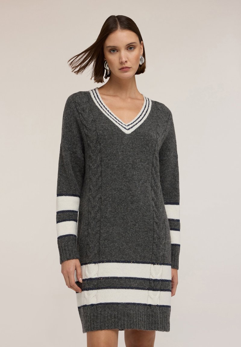 Abito grigio a maglia con scollo a V, texture a trecce e dettagli a righe bianche e navy sulle maniche e sull'orlo. Maniche lunghe, lunghezza sopra il ginocchio.