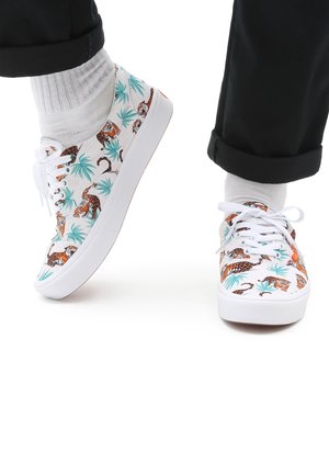 Baskets en toile blanche avec un motif tropical de tigre, comprenant des feuilles vertes et des tigres orange, des lacets blancs et des semelles en caoutchouc.