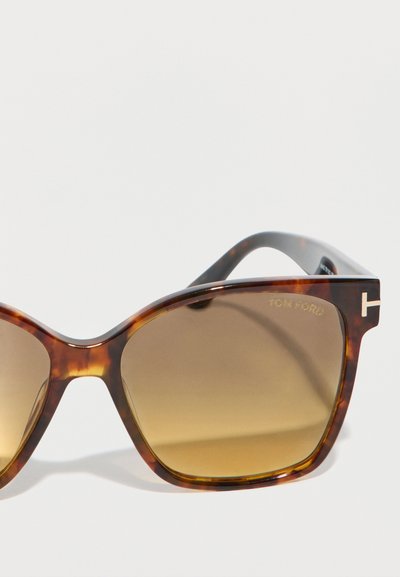 Lunettes de soleil rectangulaires écaille de tortue avec des verres dégradés marron et des branches fines, ornées d'un logo "Tom Ford" doré sur le verre.