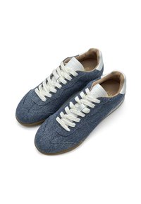 Denim sneakers met een donkerblauwe bovenkant, witte veters en een interior van bruin leer. Rubberen zool met een gladde textuur en een rond teenontwerp.
