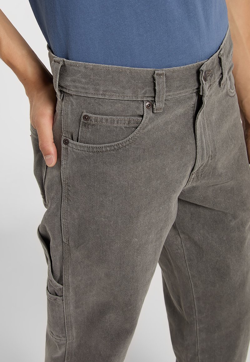 Pantalones de algodón grises con corte de pierna recta, que cuentan con bolsillos delanteros, cierre de cremallera y un diseño casual de cintura. Textura suave con un brillo sutil.