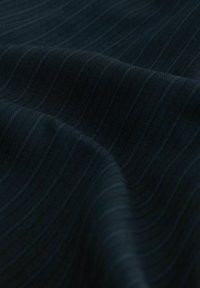 Dunkelblaues Stoff mit einer glatten Textur, versehen mit subtilen vertikalen Streifen in einem etwas helleren Blau. Der Fall erzeugt sanfte Wellen.