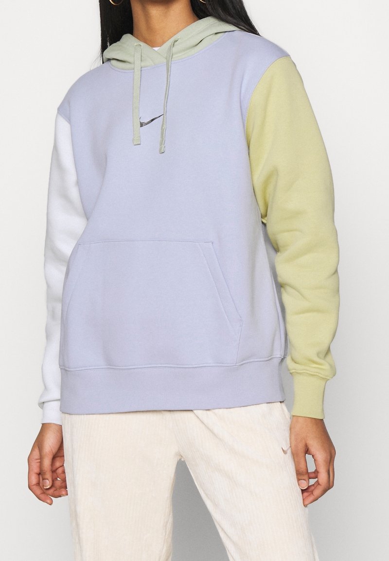 Färgblockerad hoodie i lavendel, vitt och ljusgrönt; har en framficka, dragsnodd på huvan och en liten logotyp på bröstet.