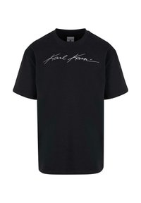 Černé bavlněné tričko s krátkým rukávem, s bílým kurzívním textem "Karl Kani" na hrudi. Klasický design s kulatým výstřihem.
