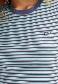 Randig t-shirt i blått, marinblått och teal. Har en rund halsringning med en enfärgad kant och en liten Levi's-logotyp på framsidan.