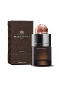 Molton Brown Heavenly Gingerlily Eau de Parfum in einer dunklen Glasflasche mit einem rosa kugelförmigen Deckel, verpackt in einer braunen strukturierten Schachtel.