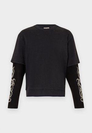 Schwarzes Kurzarmshirt mit langen schwarzen Ärmeln, das graue Tribal-Designs zeigt. Hergestellt aus weichem Stoff mit einer entspannten Passform und einem runden Halsausschnitt.