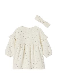 Kleid in Cremefarbe mit schwarzen Herzen, Rüschenärmeln und ausgestelltem Oberteil. Inklusive passendem Haarband. Weicher, strukturierter Stoff.